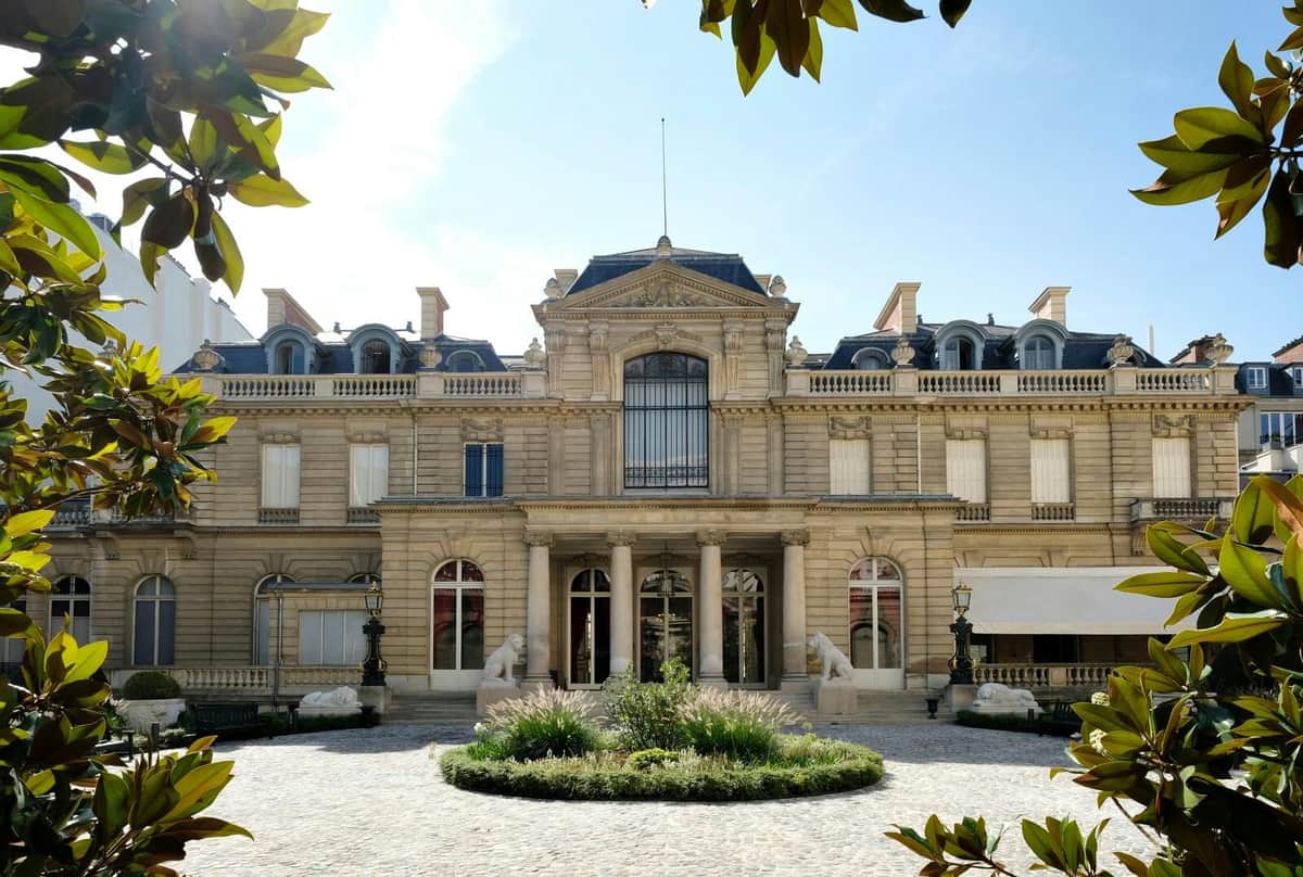 Musée Jacquemart-André: Skip The Line Ticket A grand historical building with large windows, decorative columns at the entrance, and a cobblestone courtyard.