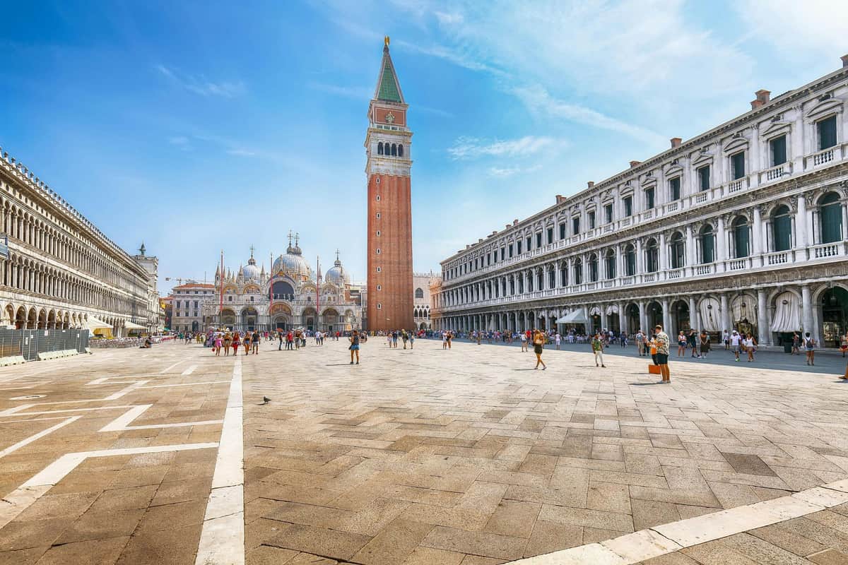 St. Mark's Basilica & Bell Tower Tour St. Mark's Square in Venice with the bell tower and St. Mark's Basilica in the background, surrounded by historic buildings and tourists.