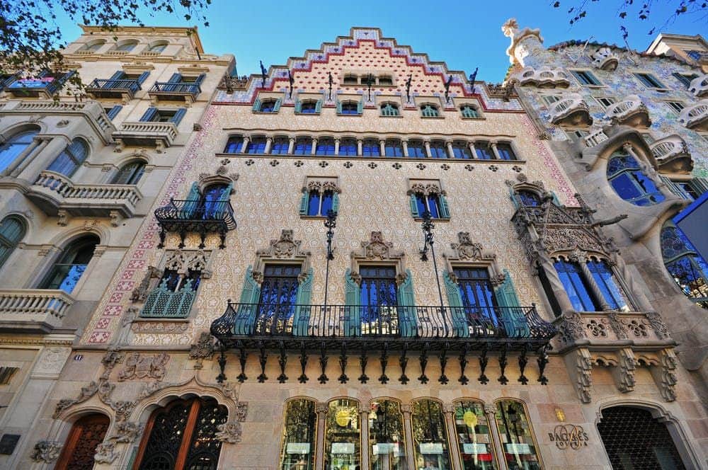 Casa Amatller: Skip The Line Ticket + Audio Guide Ornate building facade featuring decorative patterns, iron balconies, and arched windows, with a stepped roofline under a clear sky.