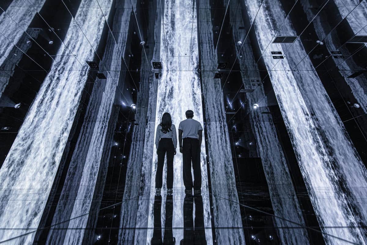 ARTE MUSEUM DUBAI: VIP Ticket Two people standing in a mirrored room with illuminated vertical light strips, creating a futuristic and reflective environment.