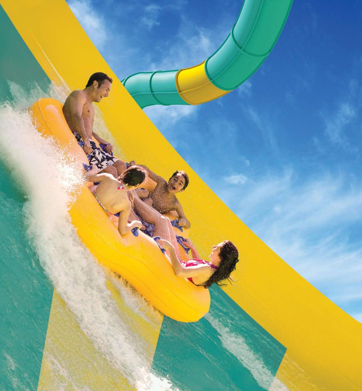 Adventure Island Tampa Bay: Fast Track Four people riding a yellow inflatable raft on a water slide under a bright blue sky.
